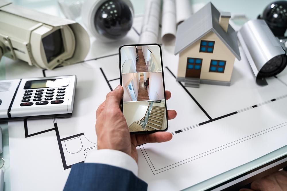 A Person Is Holding A Cell Phone With A Picture Of A House On It — Highfields Antennas In Crows Nest, QLD