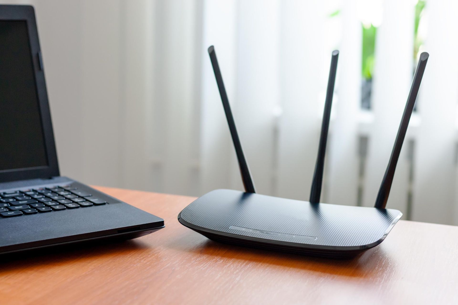 A Laptop And A Router Are Sitting On A Wooden Table — Highfields Antennas In Pittsworth, QLD