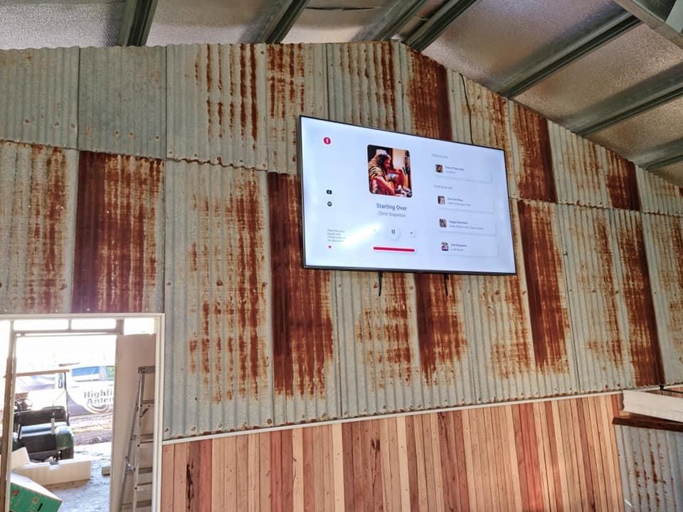 A Rusty Wall With A Tv Mounted On It — Highfields Antennas In Cabarlah, QLD
