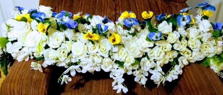 White and yellow flower garland laid on a brown woven mat