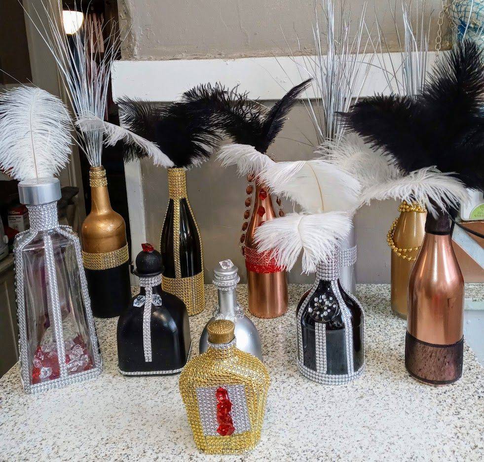 Assorted decorative perfume bottles with black and white feather toppers displayed on a countertop.