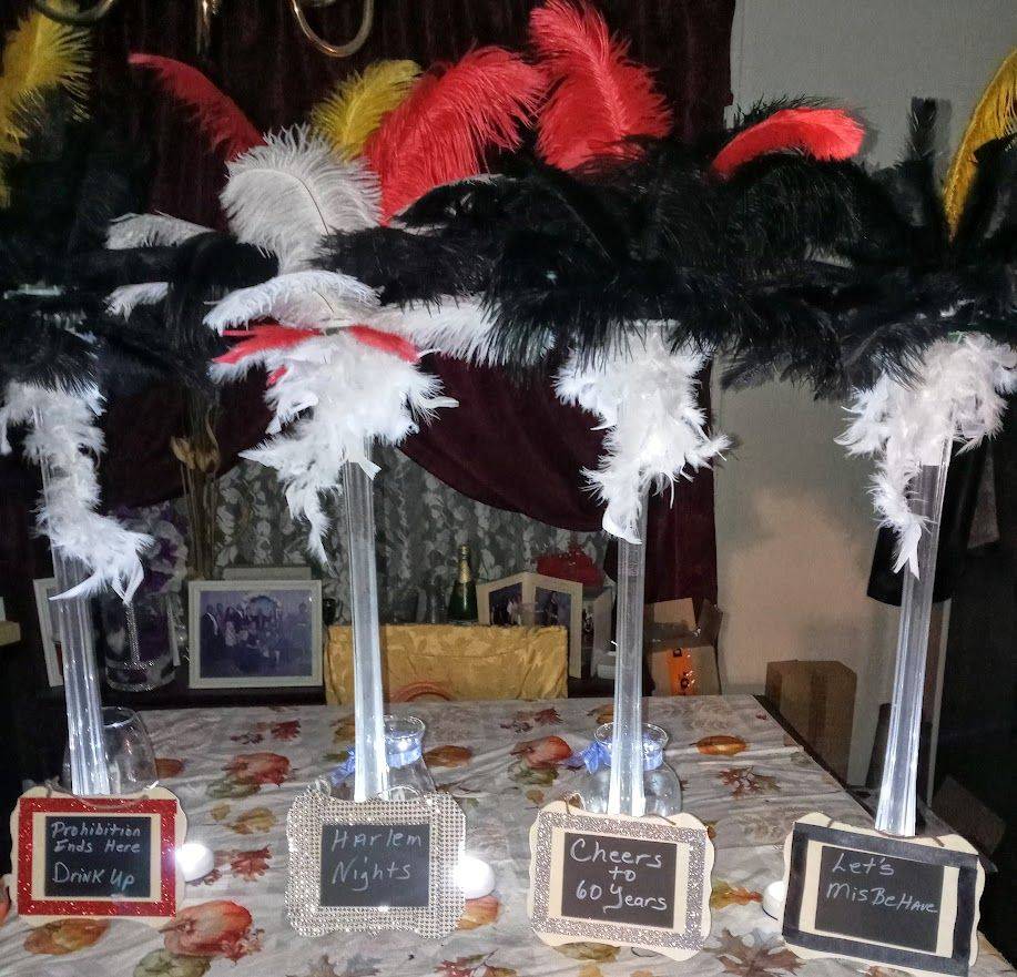 Feathered black, white, and red headpieces displayed on a table with small labeled signs.