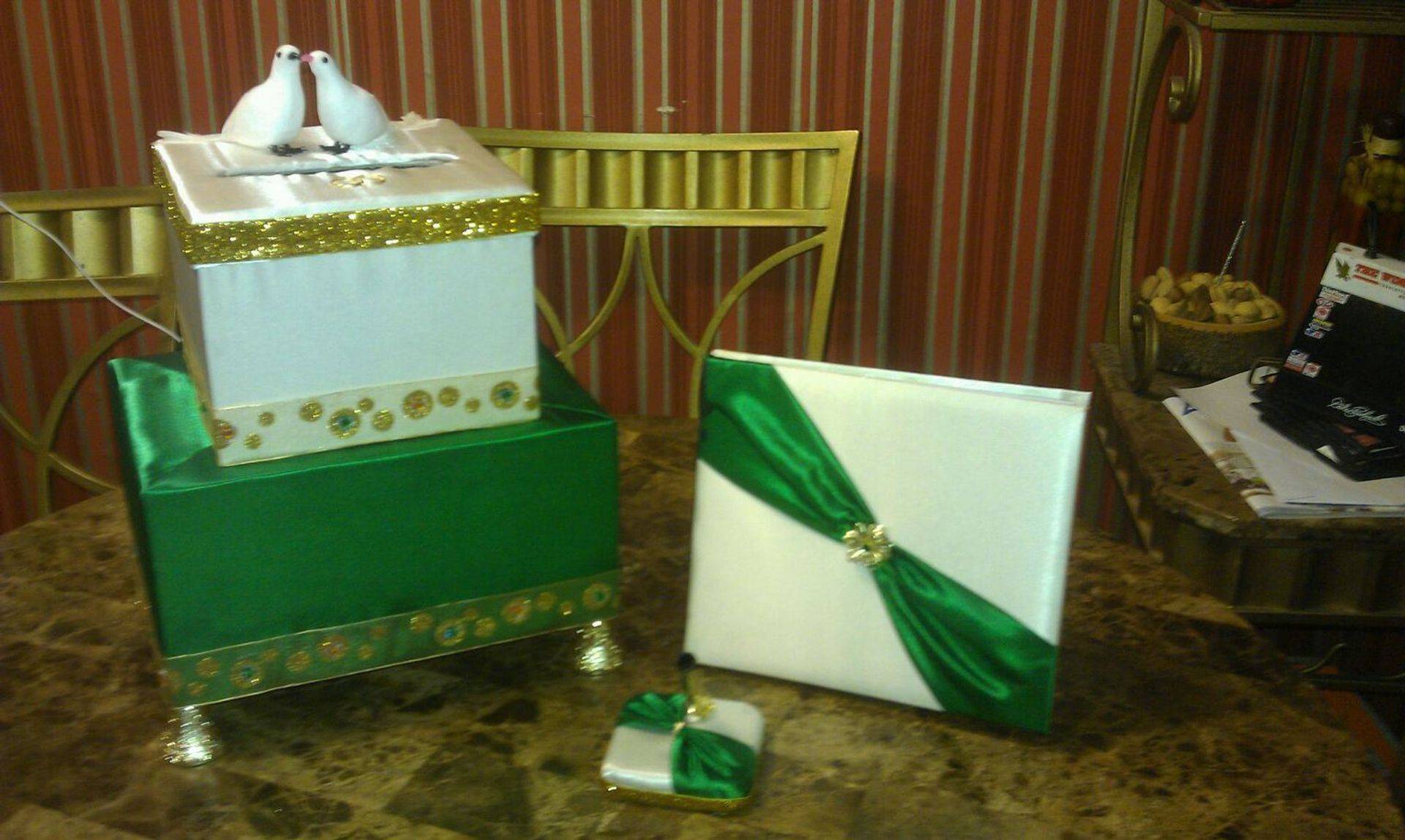 Decorative gift boxes and a wrapped present on a table with striped wallpaper background