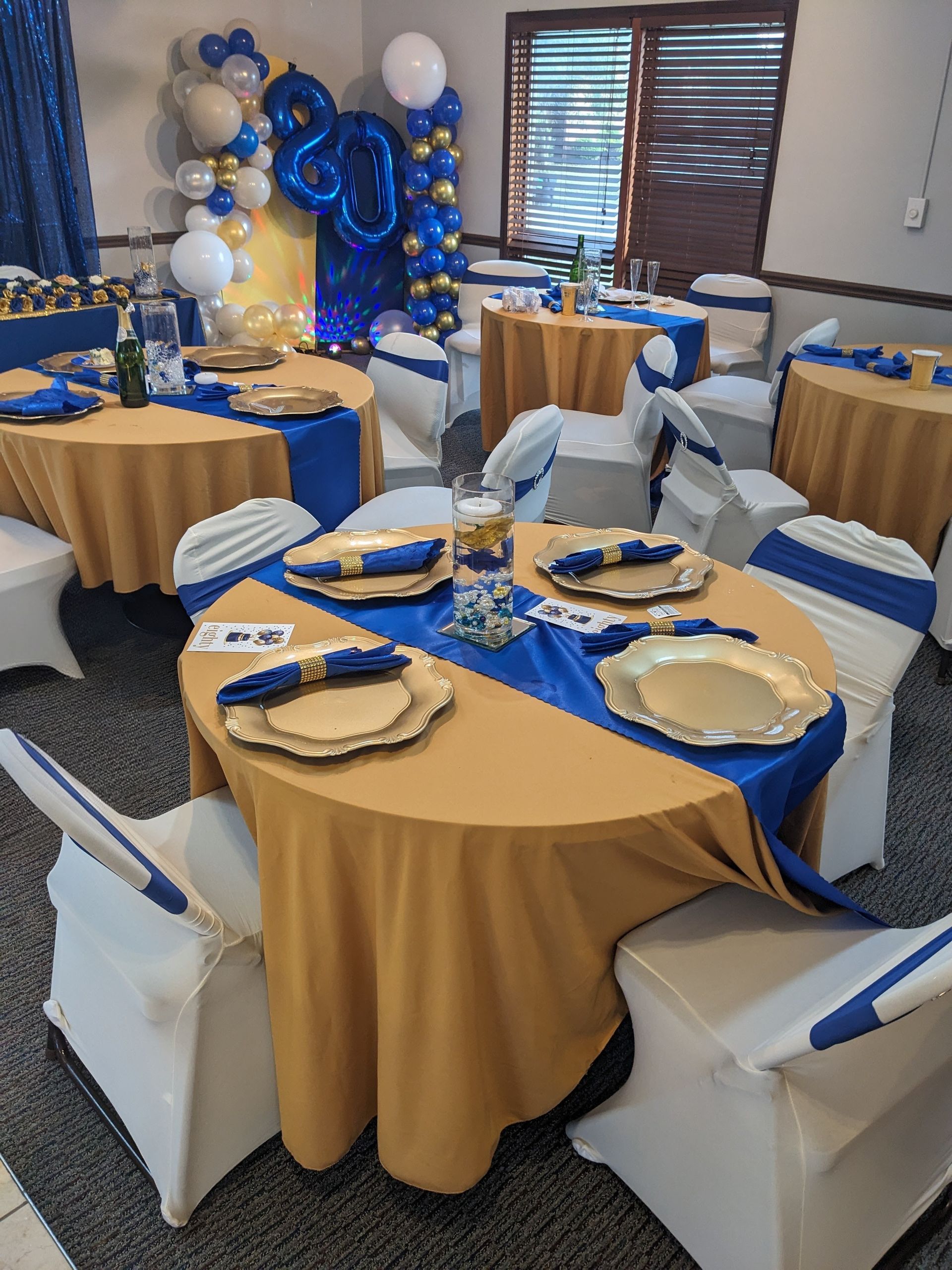Blue and gold decorated banquet tables with white chairs in a banquet room
