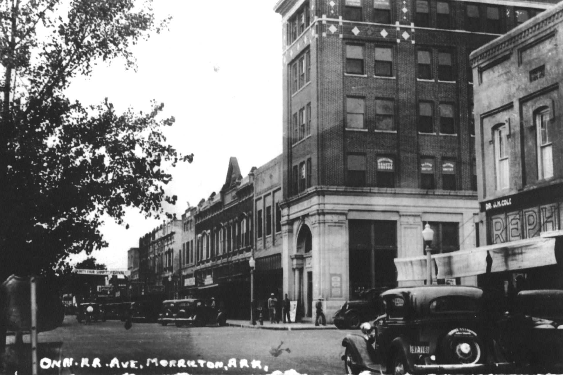 Historic black-and-white street scene with cars and buildings in historic conway county