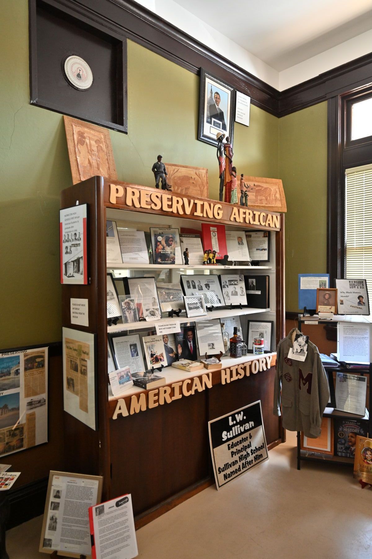 Preserving American history exhibit with photos and signs in a museum display case in Conway County History Museum