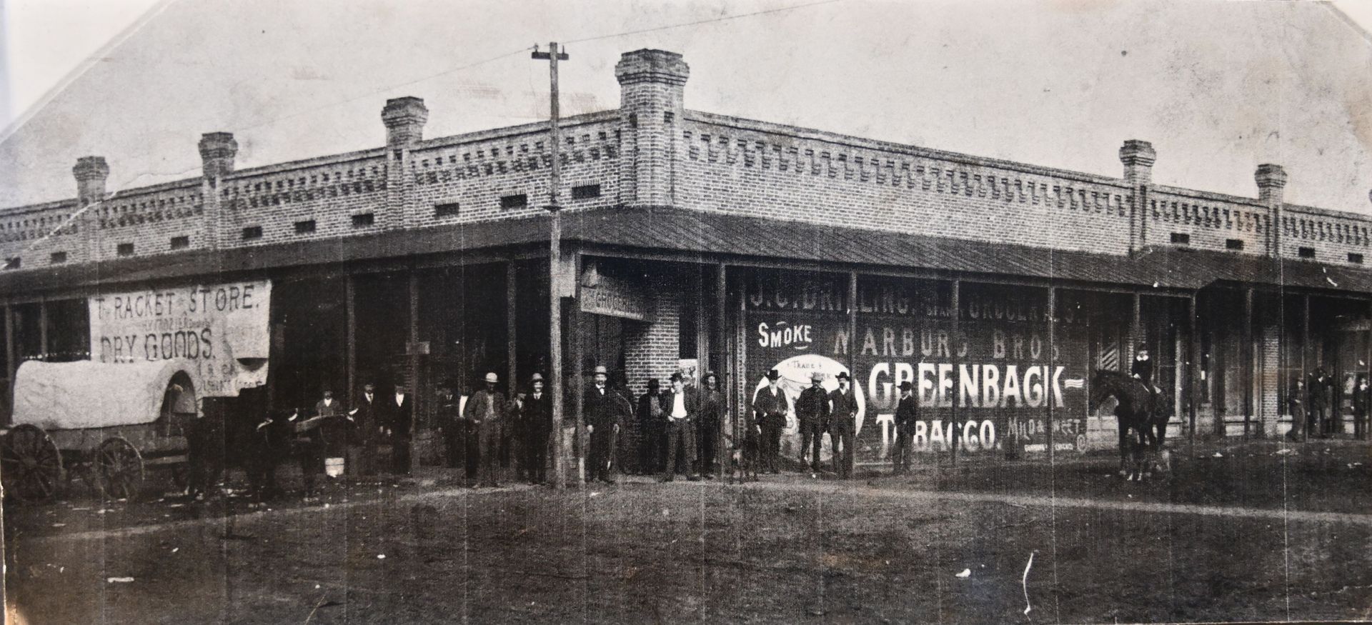 Black-and-white photo of a corner storefront with people gathered outside, likely a market or hotel historic conway county