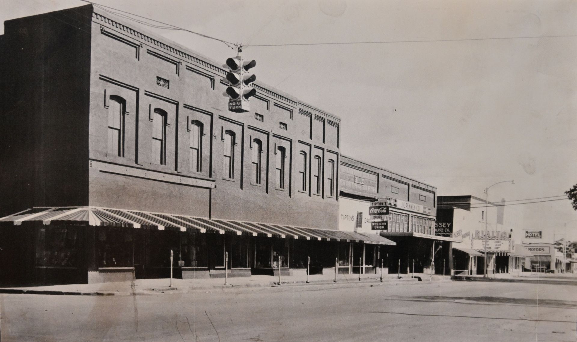 Historic Conway County Main Street with brick storefronts, awnings, and empty road in a small town.