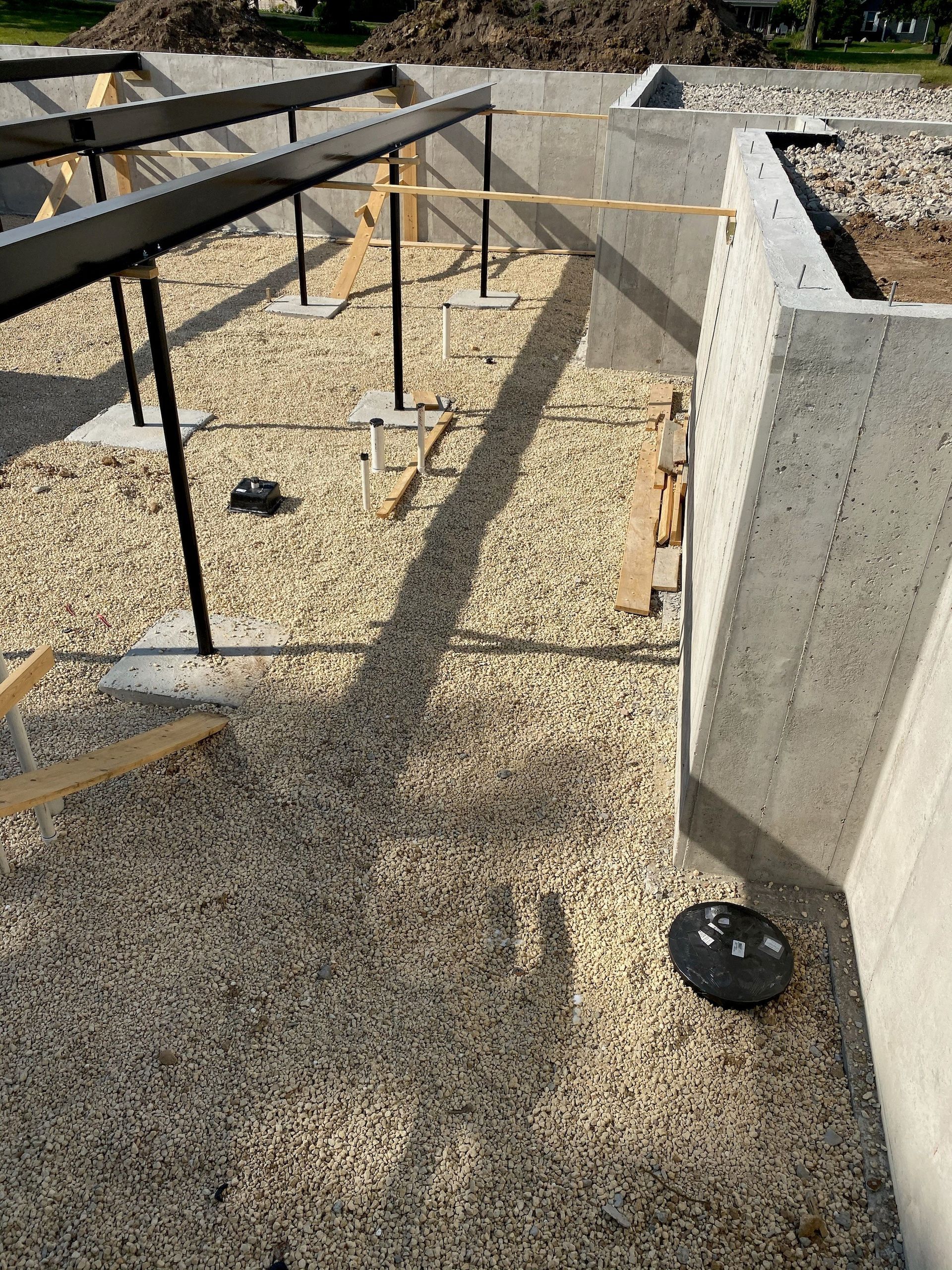 A concrete wall is being built on a gravel ground.