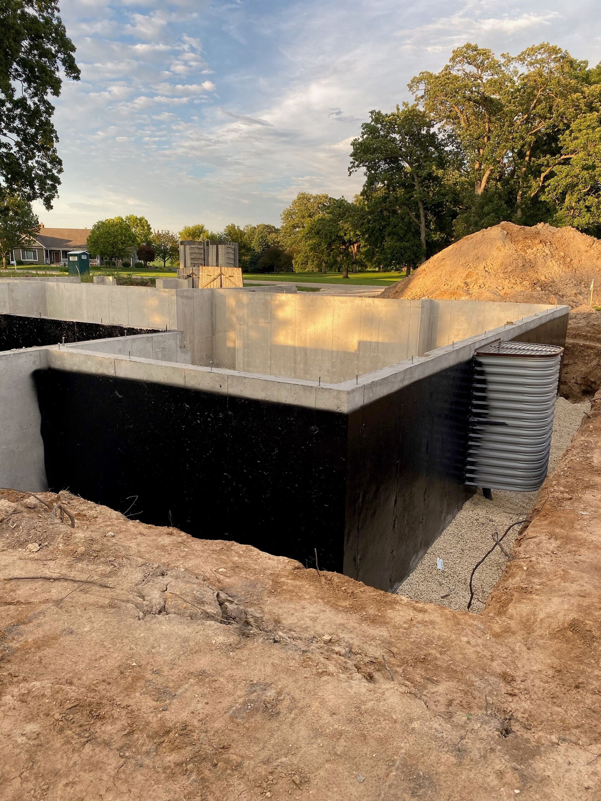A large concrete foundation is being built in a dirt field.
