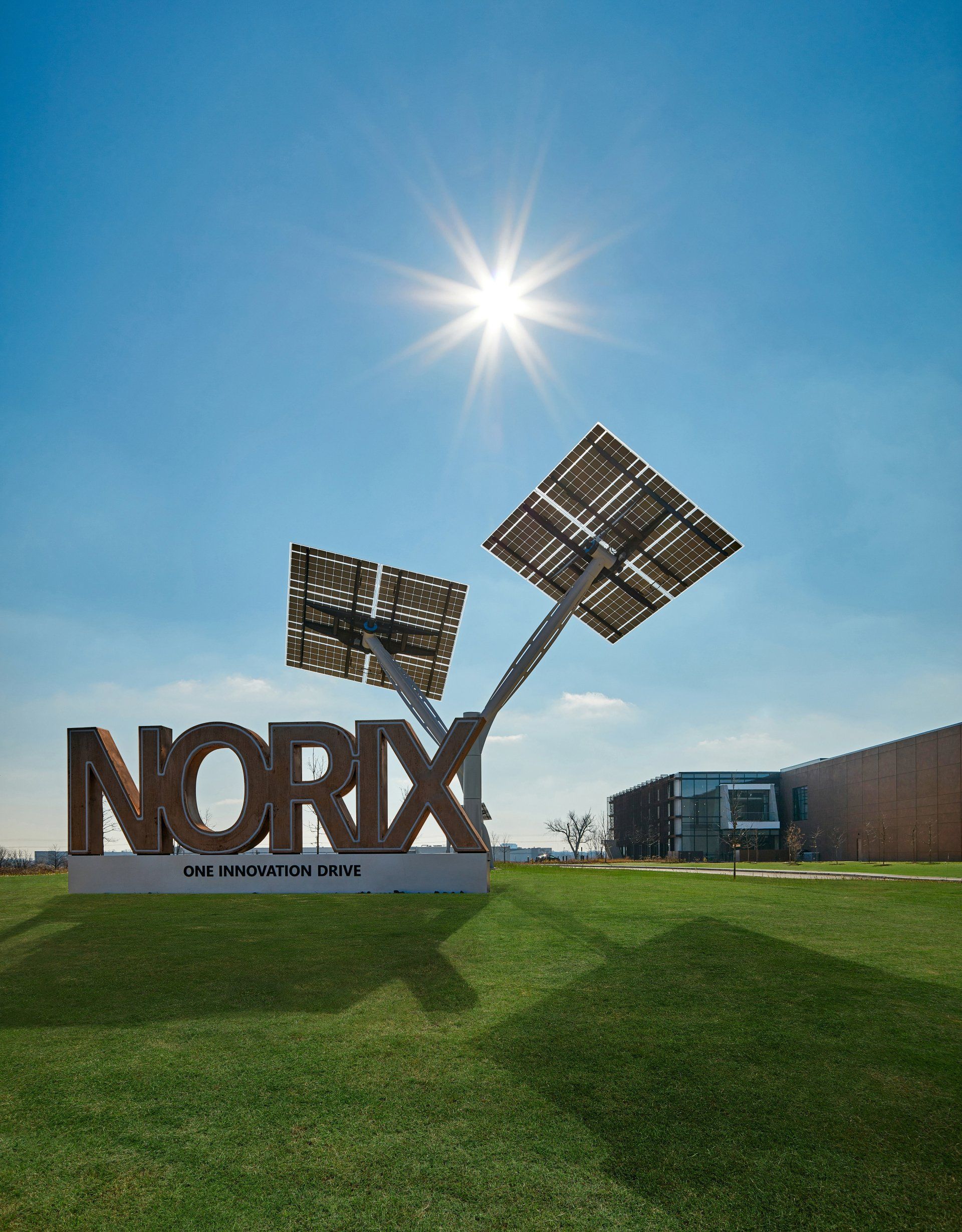 The sun is shining brightly behind a sign that says norix