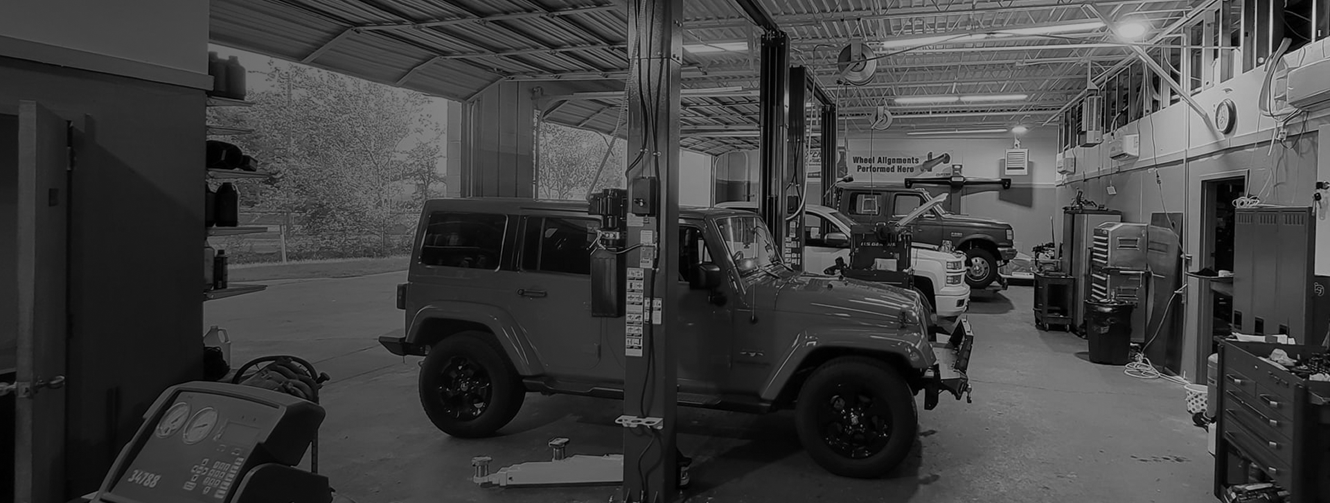 A black and white photo of a jeep in a garage. | Pearland Automotive