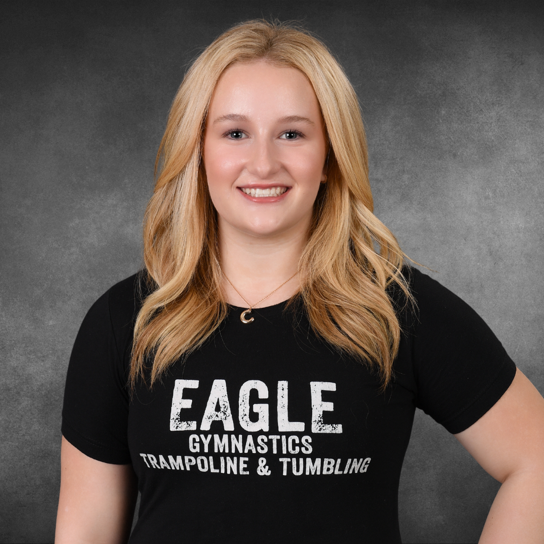 A woman wearing a black eagle gymnastics trampoline and tumbling shirt
