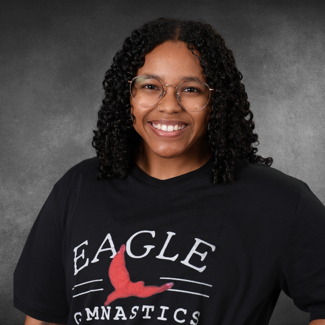 A woman wearing a black eagle gymnastics shirt