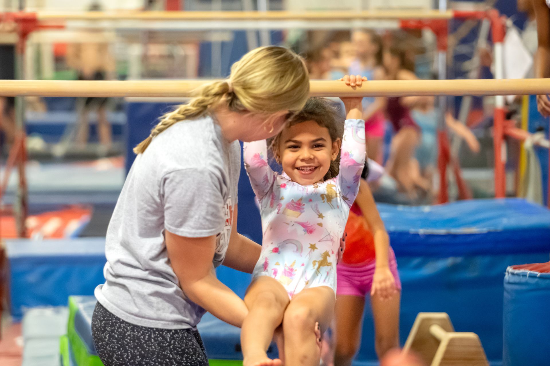 A group of young girls are practicing gymnastics in a gym.