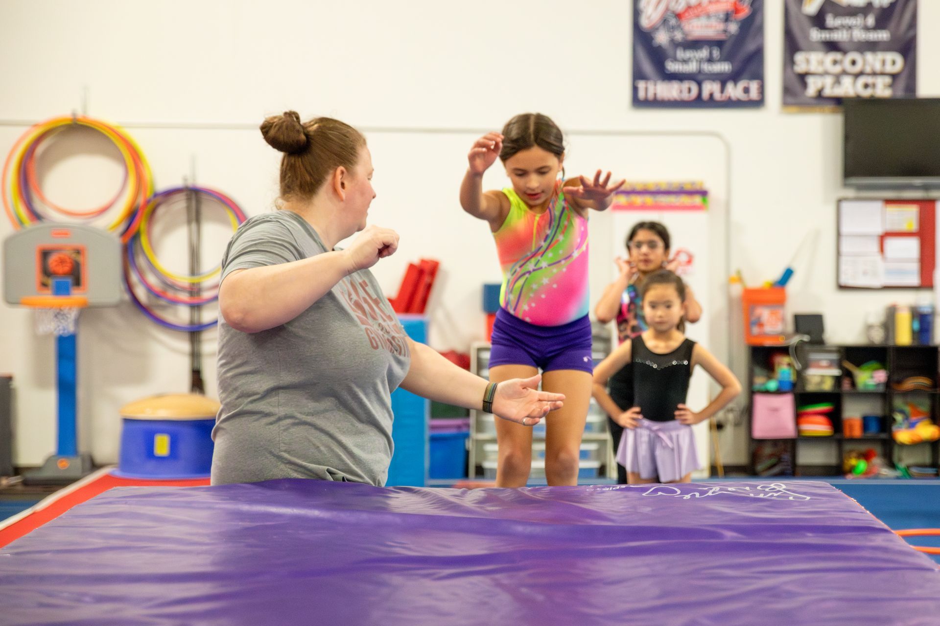 A female gymnast is doing a flip on a trampoline.