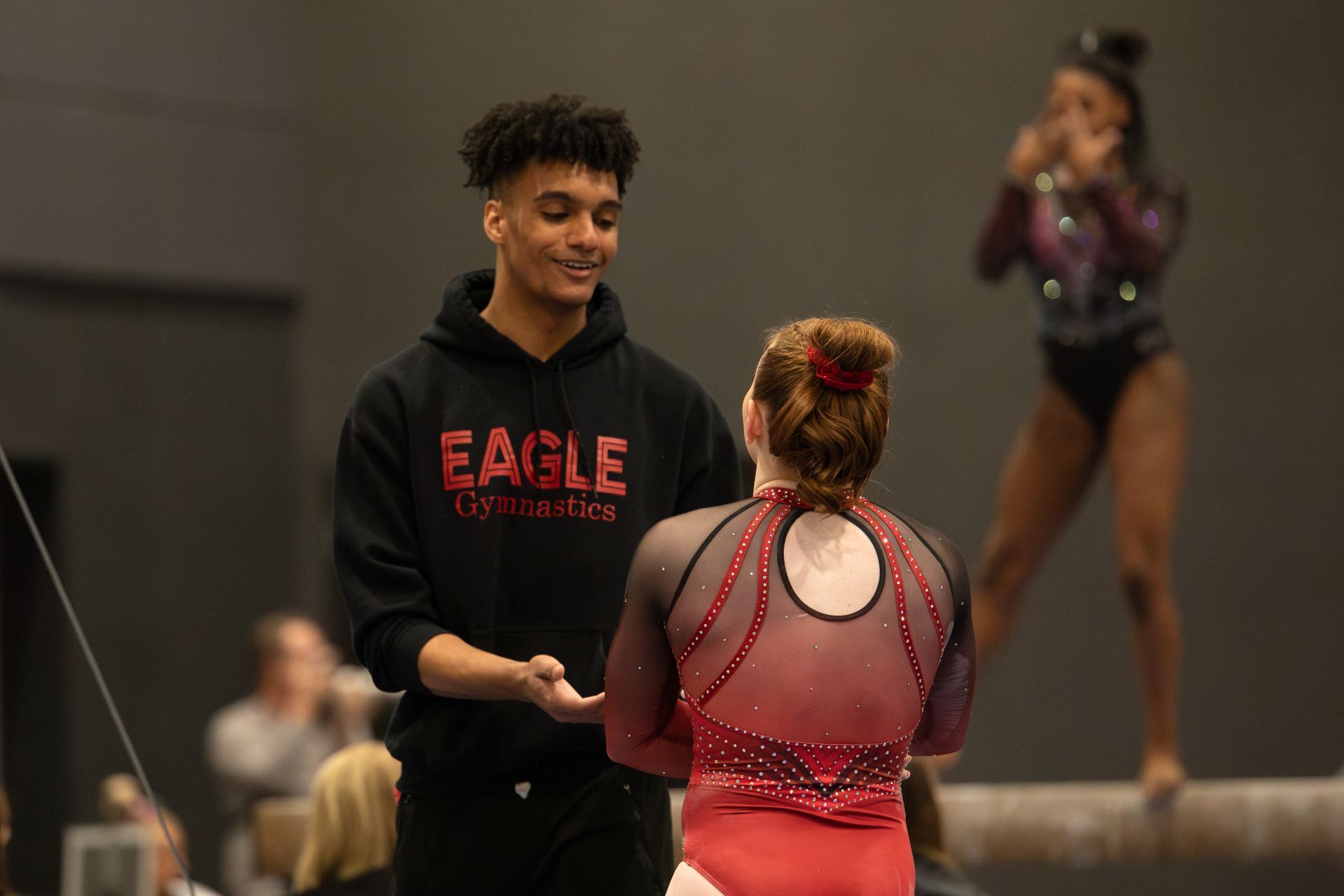 A man and a woman are standing next to each other on a balance beam.