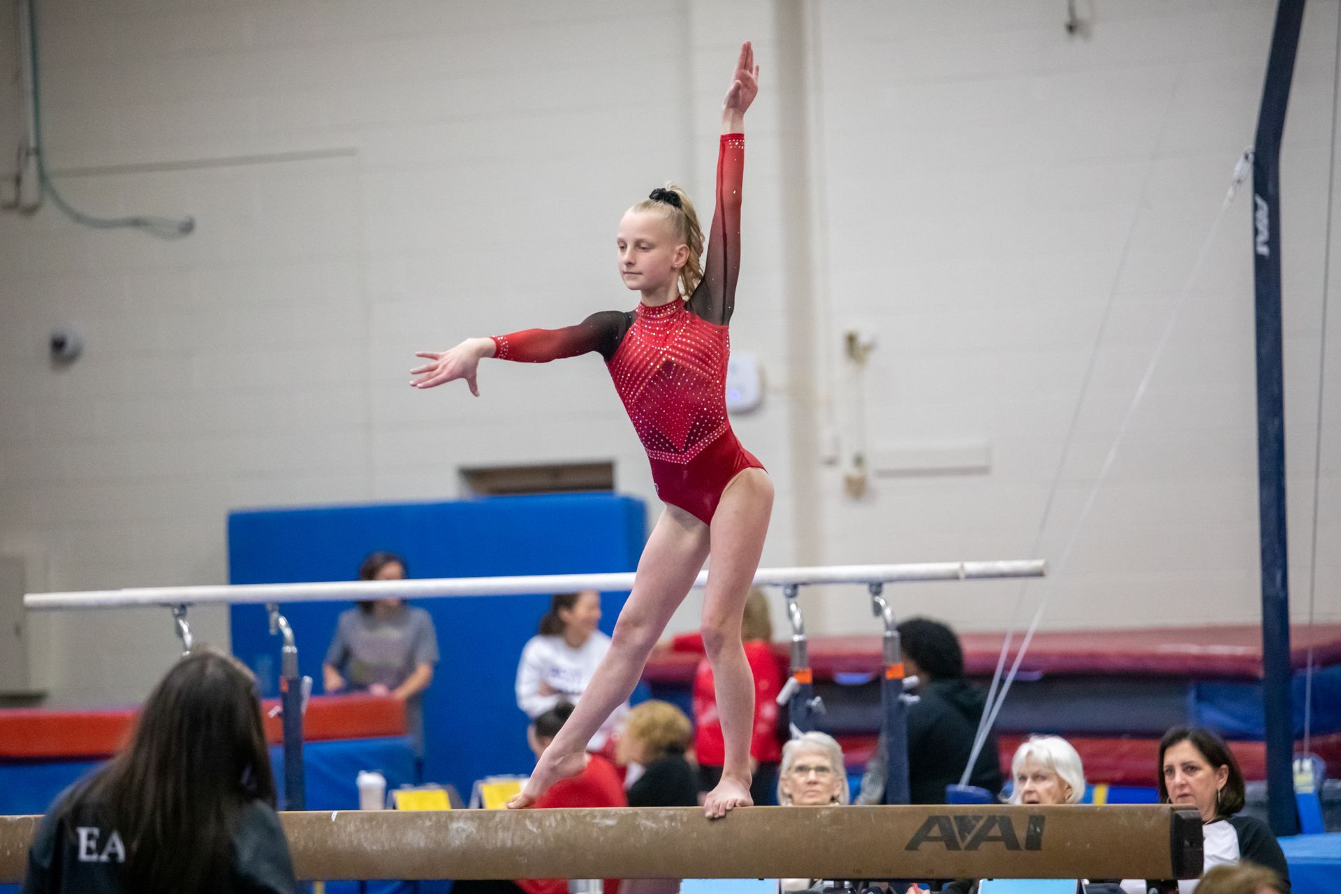 A female gymnast is doing a flip on a trampoline.