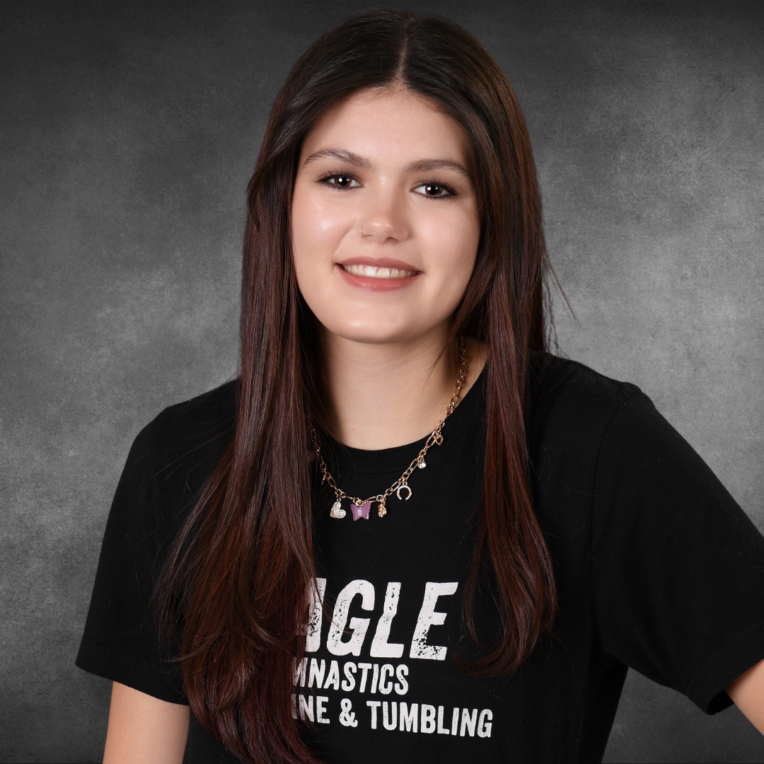 A girl wearing a black shirt that says eagle gymnastics line and tumbling