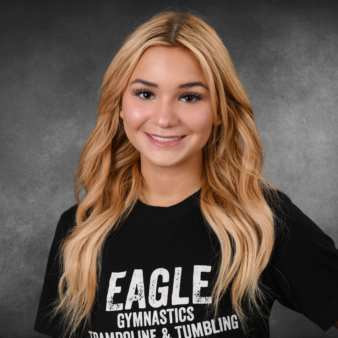 A girl is wearing a black shirt that says eagle gymnastics trampoline and tumbling