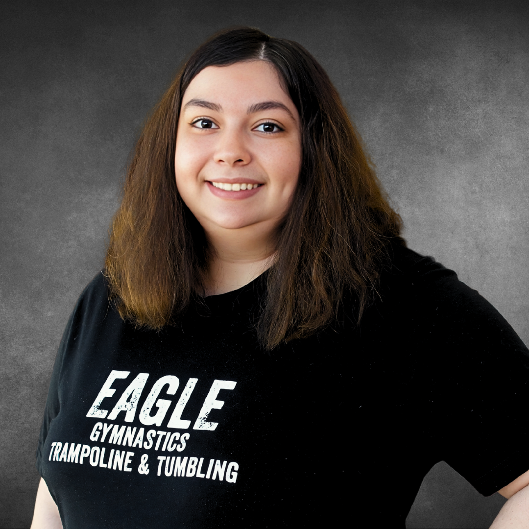 A woman wearing a black eagle gymnastics trampoline and tumbling shirt
