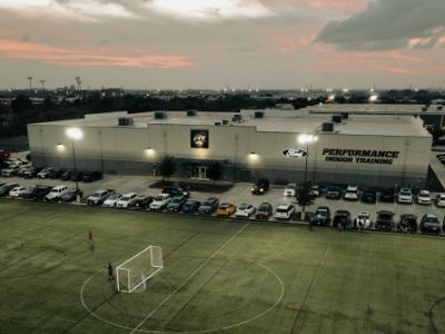 An aerial view of a soccer field in front of a large building.