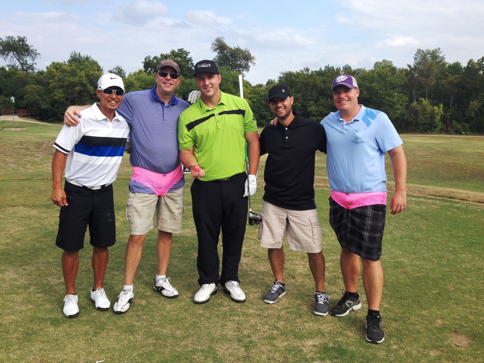 A group of men are posing for a picture on a golf course.