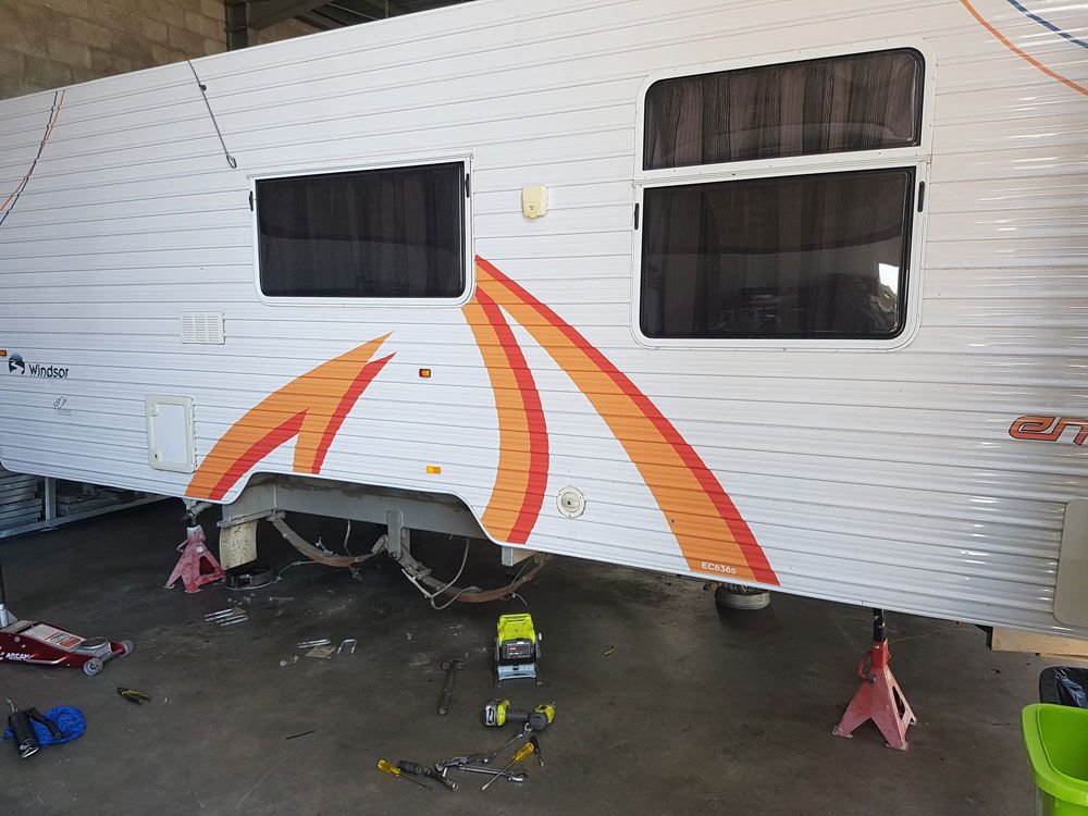 Caravan Under Repairing The Leaf Spring And Wheels On The Shop — Drop Deck Trailers In Urangan QLD