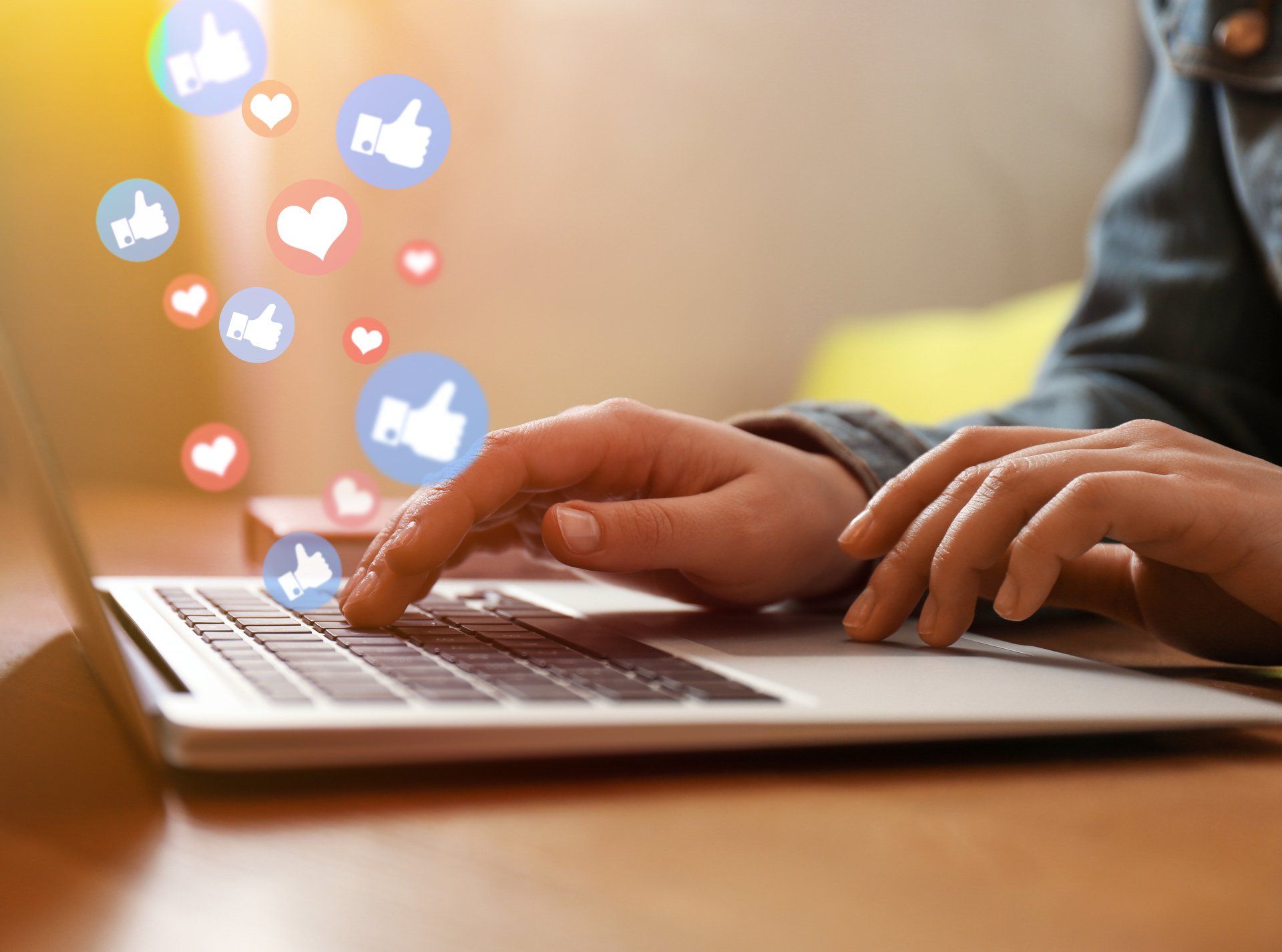 likes and heart bubbles hovering over a laptop