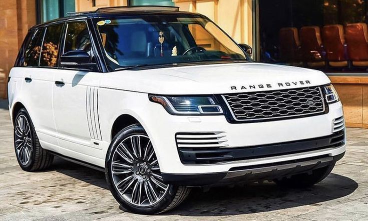 White Range Rover SUV with black roof parked outside, facing forward.