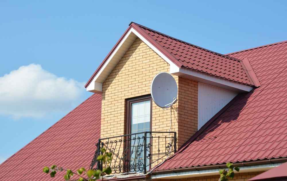 A Brick House With a Red Roof and a Balcony — Roof Restoration Masters In Budgewoi, NSW