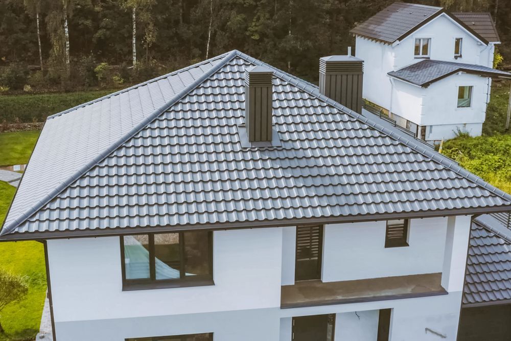 An Aerial View of a White House With a Gray Tiled Roof — Roof Restoration Masters In Gosford, NSW