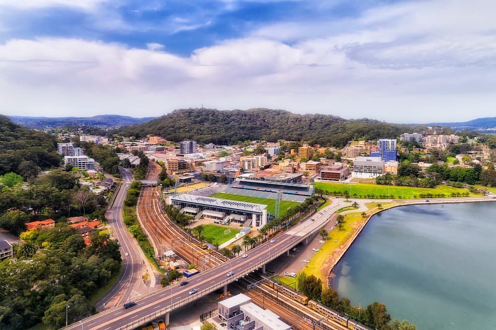 An Aerial View of a City With a Bridge Over a Body of Water — Roof Restoration Masters In Gosford, NSW