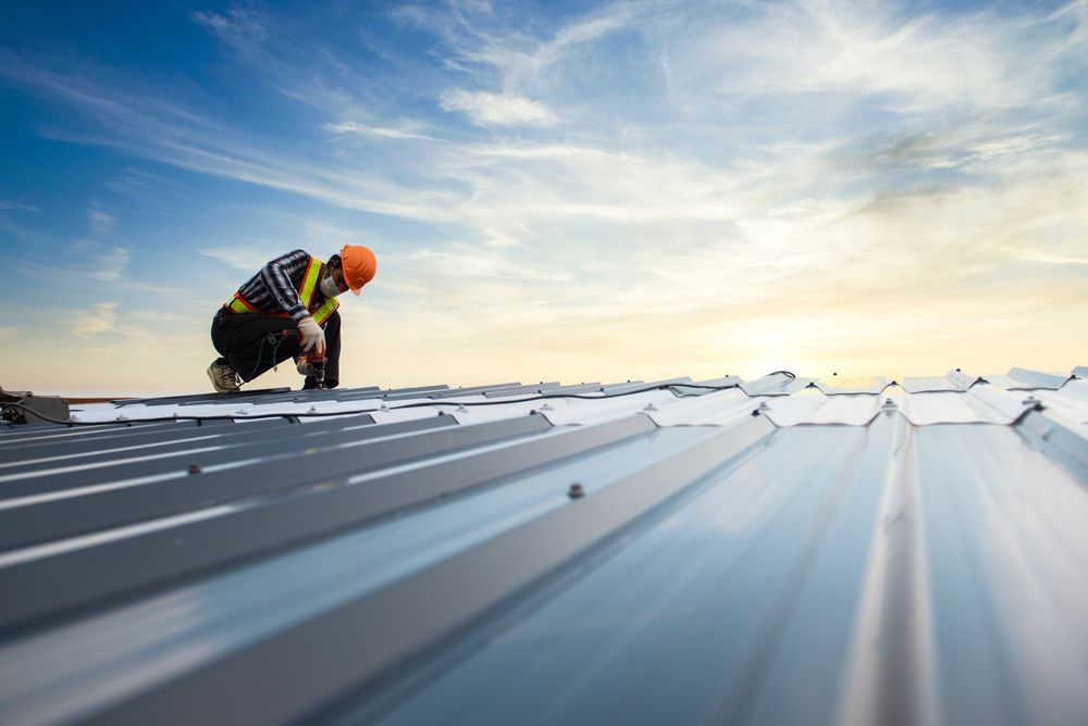 A Construction Worker is Working on a Metal Roof — Roof Restoration Masters In Thornton, NSW