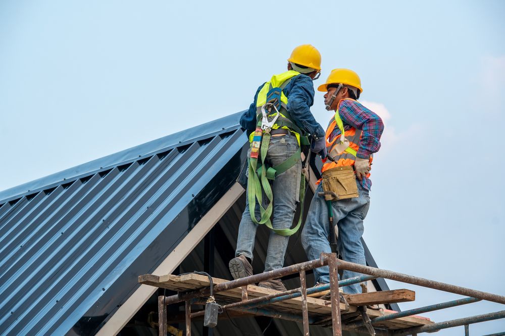 Two Workers Are Standing on a Scaffolding — Roof Restoration Masters In Cameron Park, NSW