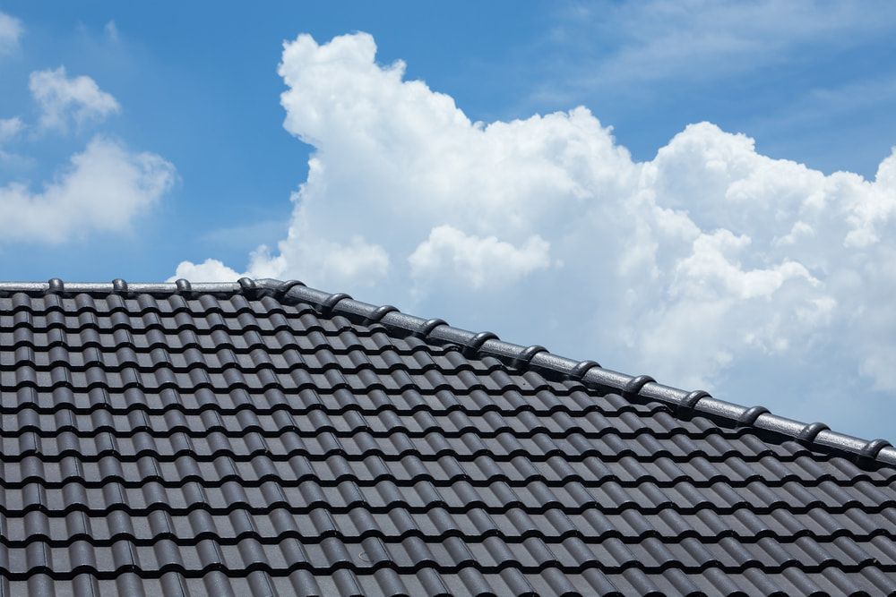 The Roof of a House With a Blue Sky and Clouds in the Background — Roof Restoration Masters In Morisset Park, NSW