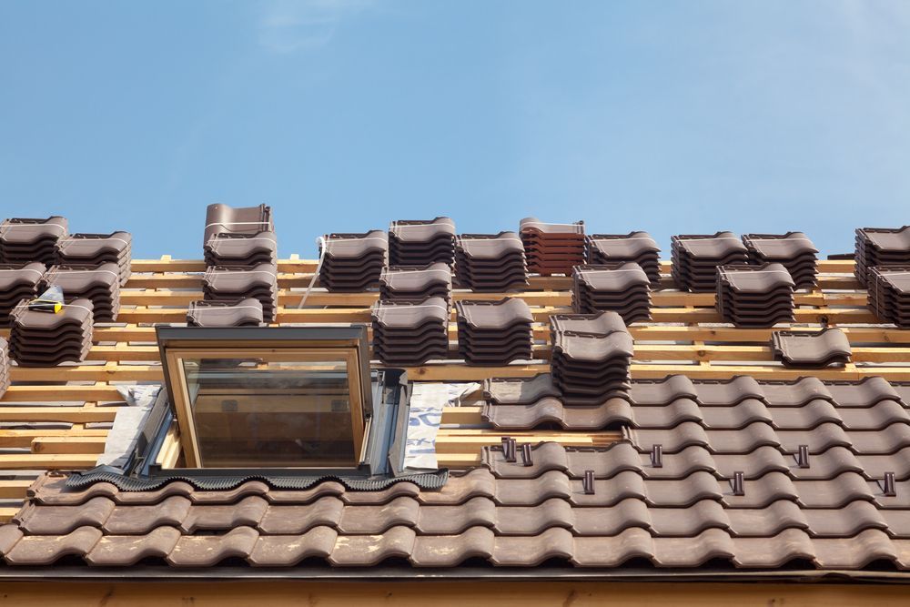 A Roof is Being Built With Tiles and a Skylight — Roof Restoration Masters In Valentine, NSW