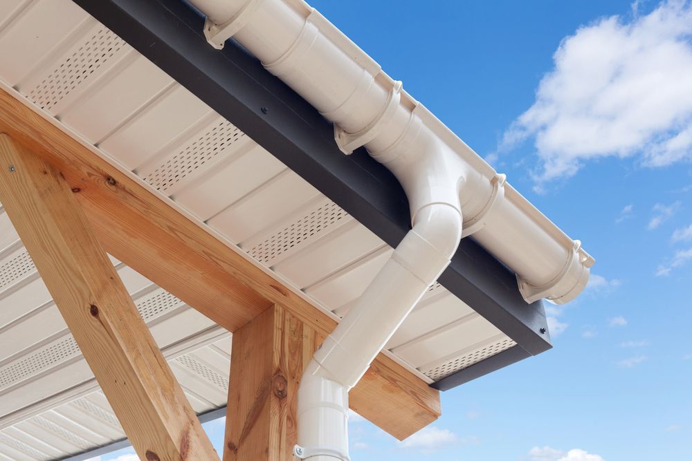 A White Gutter is Attached to the Roof of a House — Roof Restoration Masters In Thornton, NSW