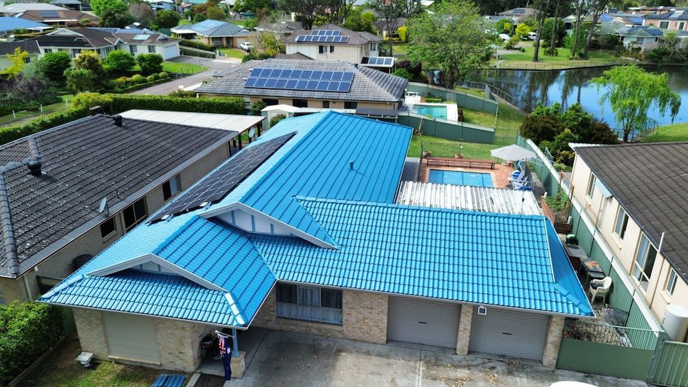 An Aerial View of a House With a Blue Roof — Roof Restoration Masters In Woongarrah, NSW