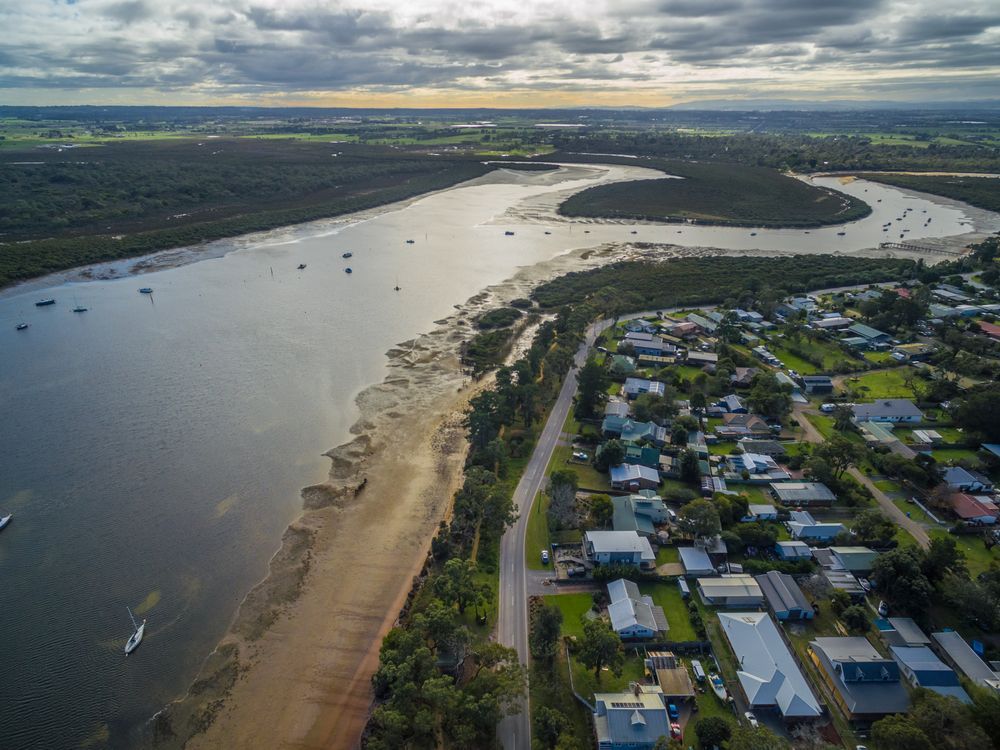 An Aerial View of a River Surrounded by Houses and Trees — Roof Restoration Masters In Rutherford, NSW