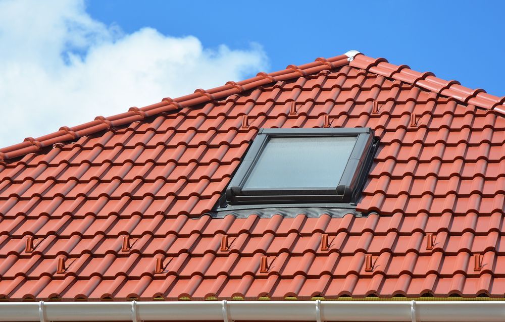 A Red Tiled Roof With a Skylight on It — Roof Restoration Masters In Rutherford, NSW