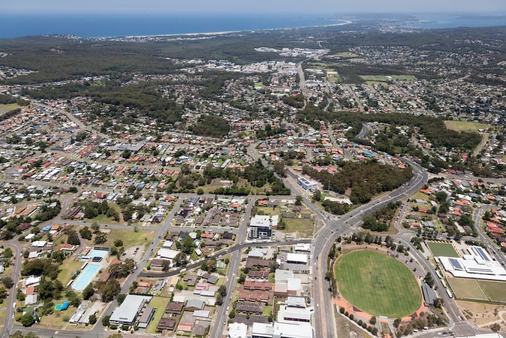 An Aerial View of a City With a Soccer Field in the Middle of It — Roof Restoration Masters In Charlestown, NSW