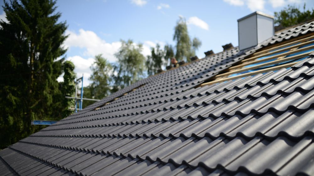 A Roof With a Lot of Tiles on It is Being Built — Roof Restoration Masters In Belmont, NSW