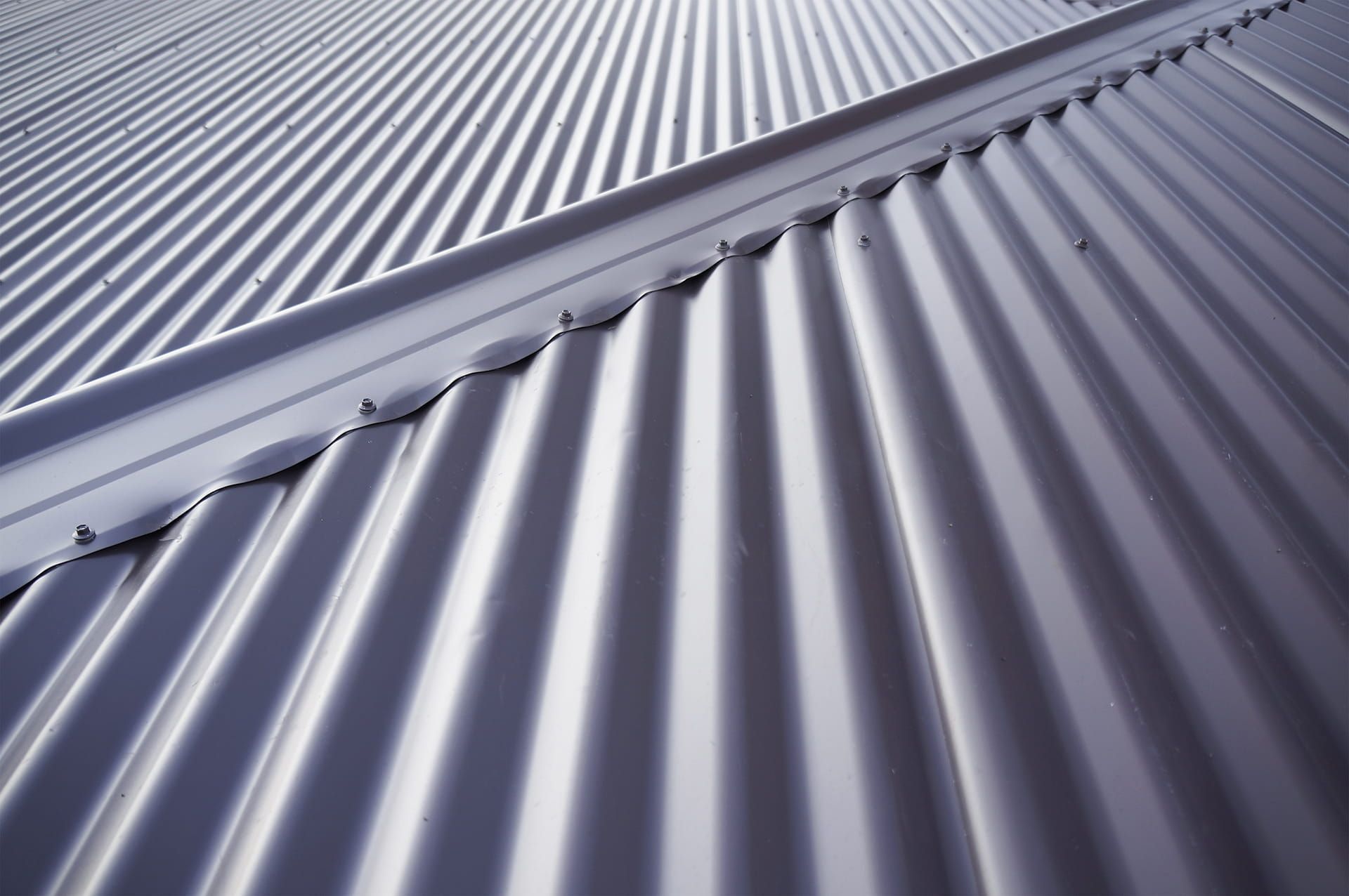 A Close Up of a Metal Roof With a Diagonal Pattern — Roof Restoration Masters In Valentine, NSW
