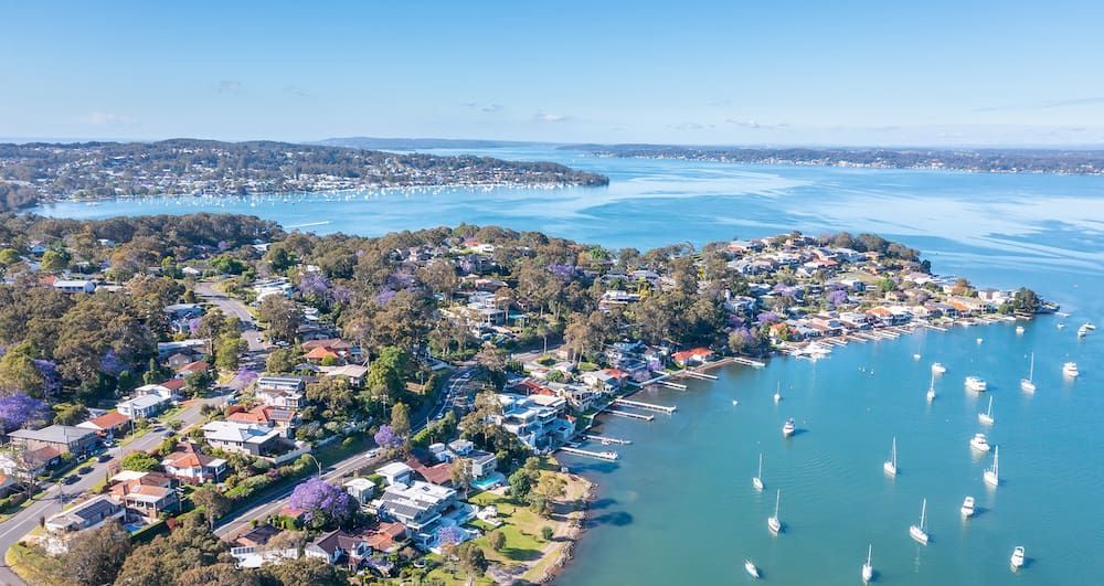 An Aerial View of a Residential Area Next to a Body of Water — Roof Restoration Masters In Eleebana, NSW
