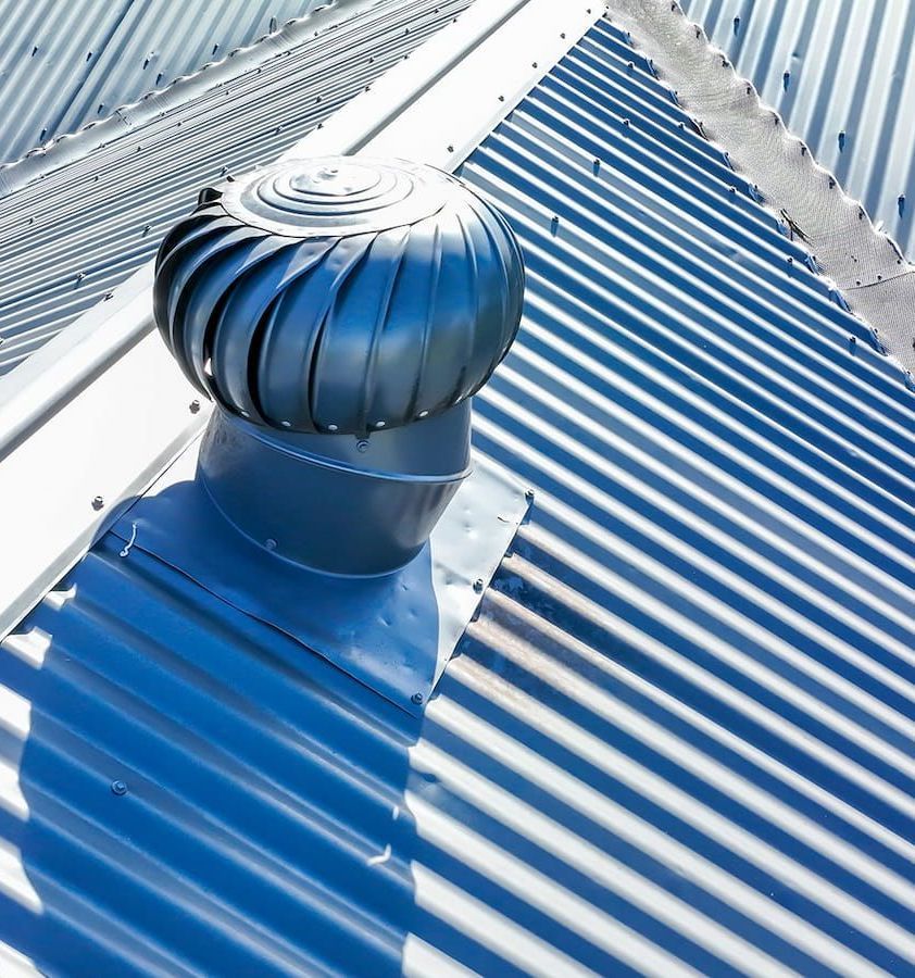 A Blue Roof With a Wind Turbine on Top of It — Roof Restoration Masters In New Lambton, NSW