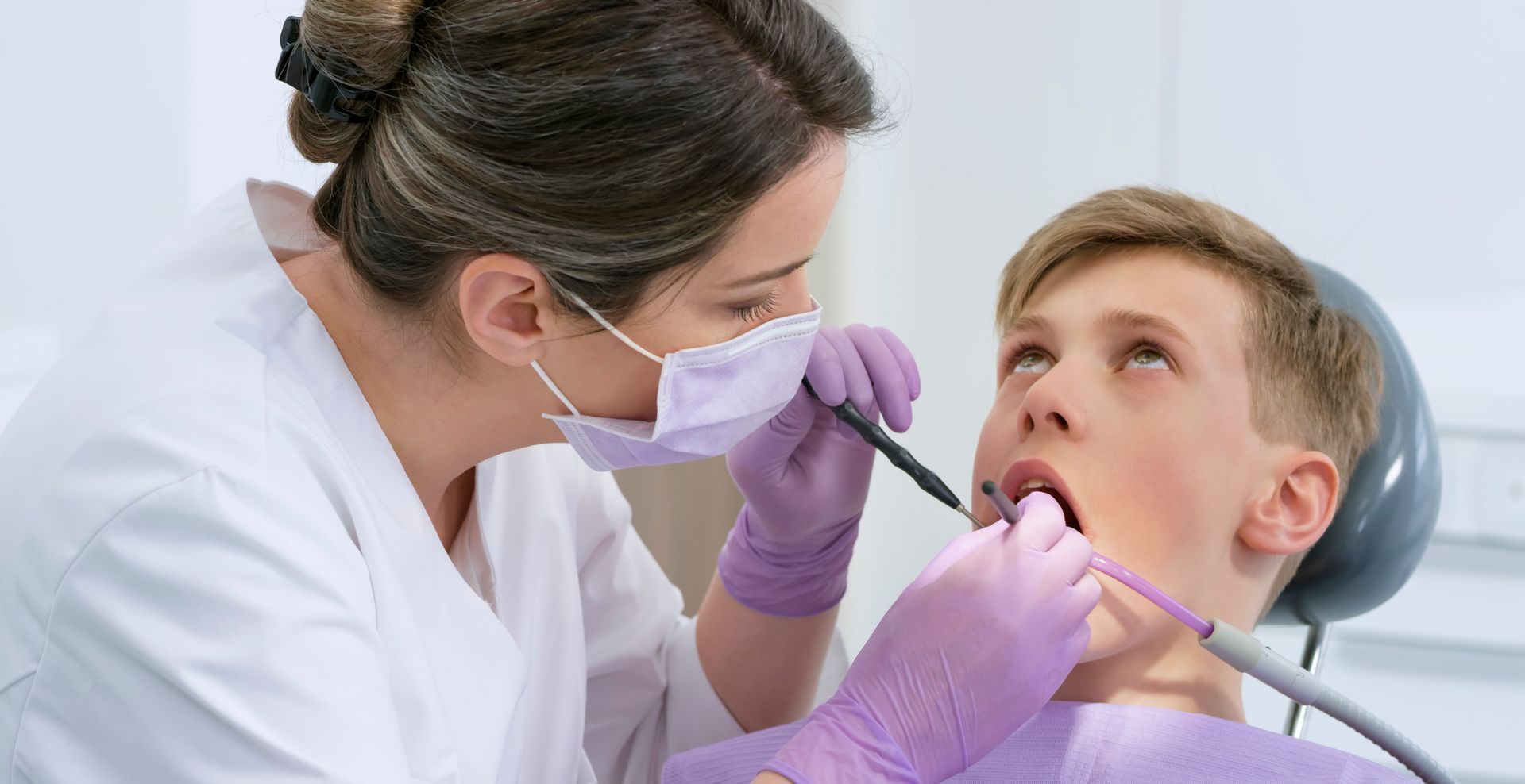 A young boy getting his tooth repaired during a procedure performed by an expert cosmetic dentist