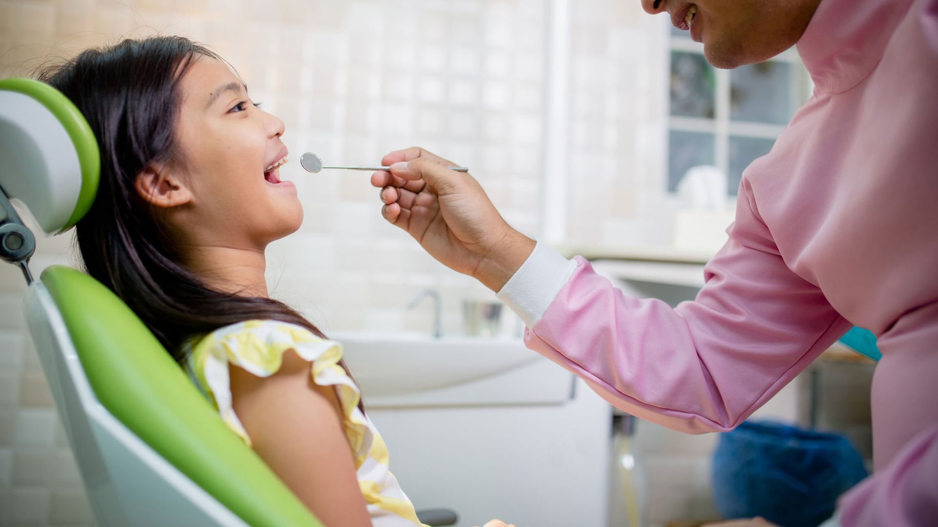 Friendly children's dentist examining a happy child's teeth in a modern dental clinic. Friendly children's dentist examining a happy child's teeth in a modern dental clinic.