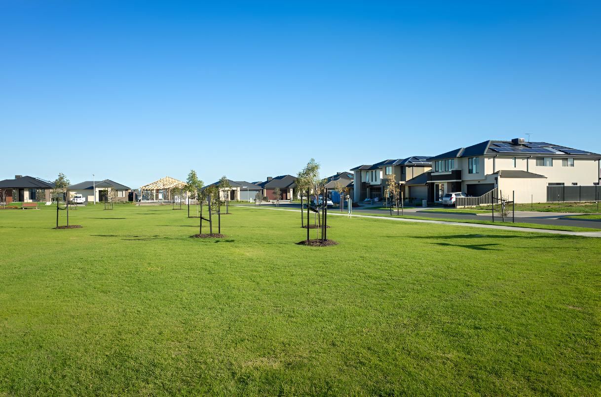 A Row Of Houses Sitting On Top Of A Lush Field — Angel Conveyancing In Larrakeyah, NT