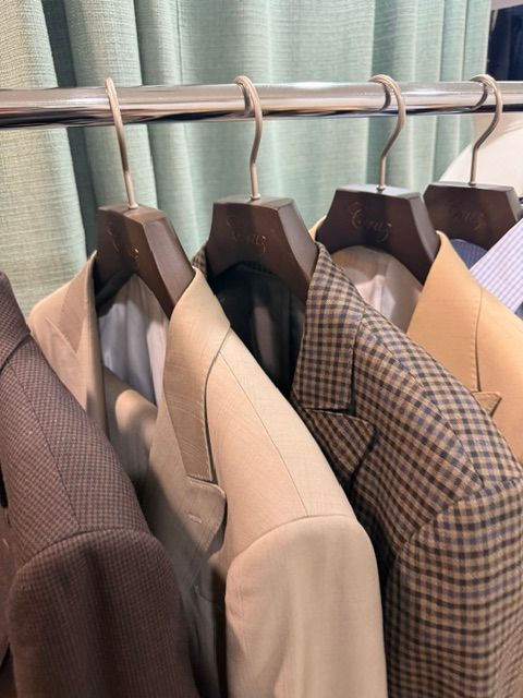 Jackets hanging on a clothing rack, varying colors and patterns.